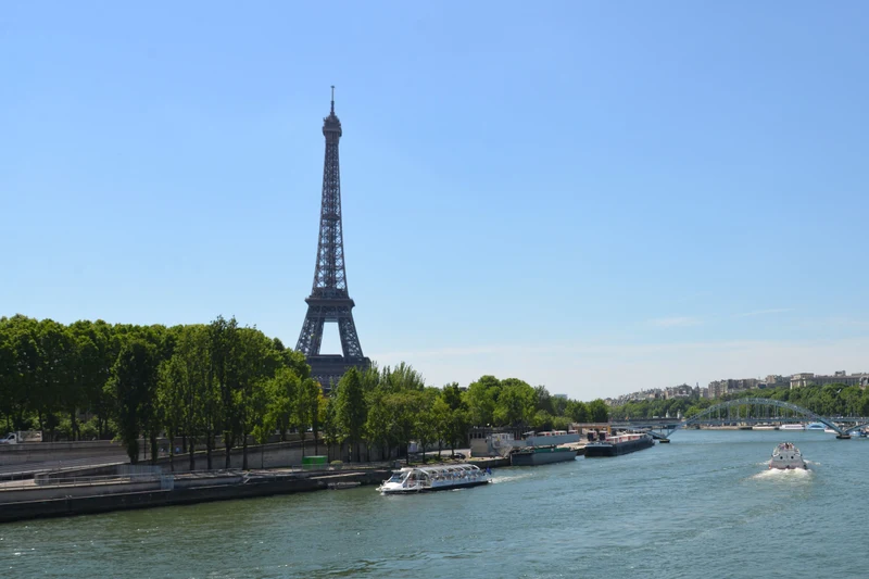 The Eiffel Tower’s summit, arch and riverside setting in daylight, Paris