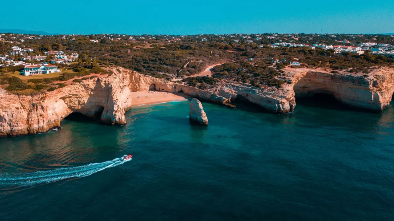 Limestone cliffs and turquoise water on the Algarve coast at Lagoa, Portugal.